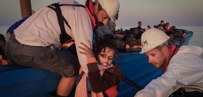 Una mujer es rescatada de un pequeño bote de madera, será llevada al barco de Médicos Sin Fronteras ©Nicolás Castellano/SER