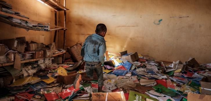 Un niño camina entre los restos de una biblioteca de una escuela primaria que fue dañada durante la crisis que irrumpió en la villa de Bisover en la región de Tigray, en Etiopía