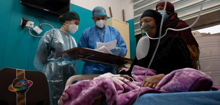 Una paciente de COVID-19 recibe oxígeno en la sala de hospitalización de MSF dentro del hospital al Kindi, en Bagdad. Las enfermeras de MSF revisan su condición y dan instrucciones al cuidador (su hijo) sobre cómo asistirla.
Hassan Kamal Al-Deen/MSF