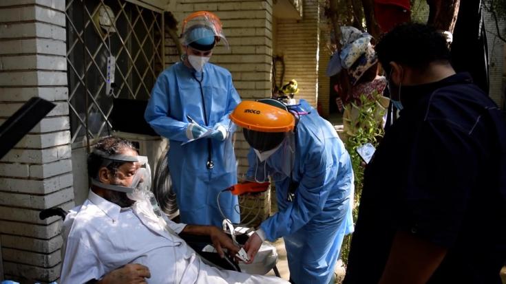 Médicos de MSF examinan a un paciente con COVID-19 en la unidad de cuidados respiratorios del hospital al Kindi en Bagdad.