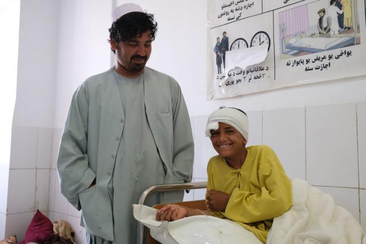 Samiullah, de 12 años, sonríe junto a su tío Ahmadullah en el hospital de Boost, tras haber sido atendida por una herida de bala que recibió en la cabeza el 4 de mayo. Ella y su madre tuvieron que viajar durante dos horas y media para llegar al hospital.