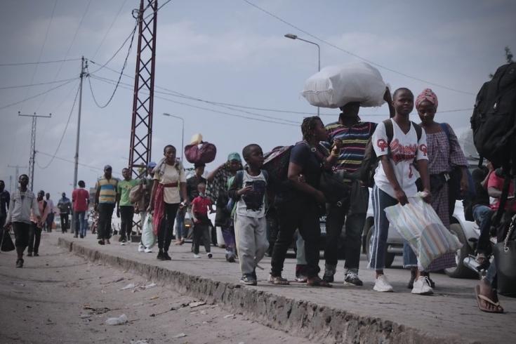 Tras la erupción del volcán Monte Nyiragongo, las personas huyen de Goma llevando sus pertenencias. República Democrática del Congo, mayo de 2021