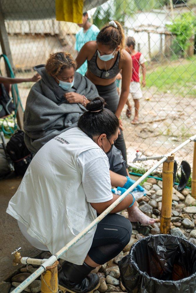 Solange se separó de su madre en la selva del Darién y llegó dos días antes que ella a Bajo Chiquito, Panamá. El día de la foto, el 12 de junio de 2021, se reunieron nuevamente. Nuestra enfermera Lucero prepara el material para lavar y curar los pies .