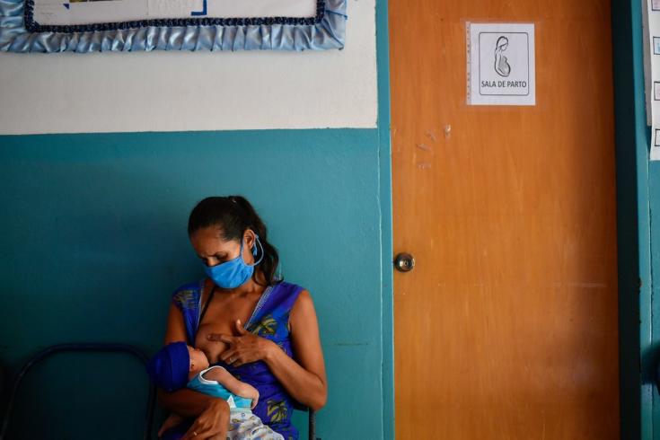 Lesser, de 28 años, amamanta a su hijo Abel mientras esperan a ser atendidos para la primera consulta de control posnatal en el Ambulatorio de San Vicente, ubicado en una población rural del estado Sucre, a tan solo 10 minutos a pie de su casa. Venezuela