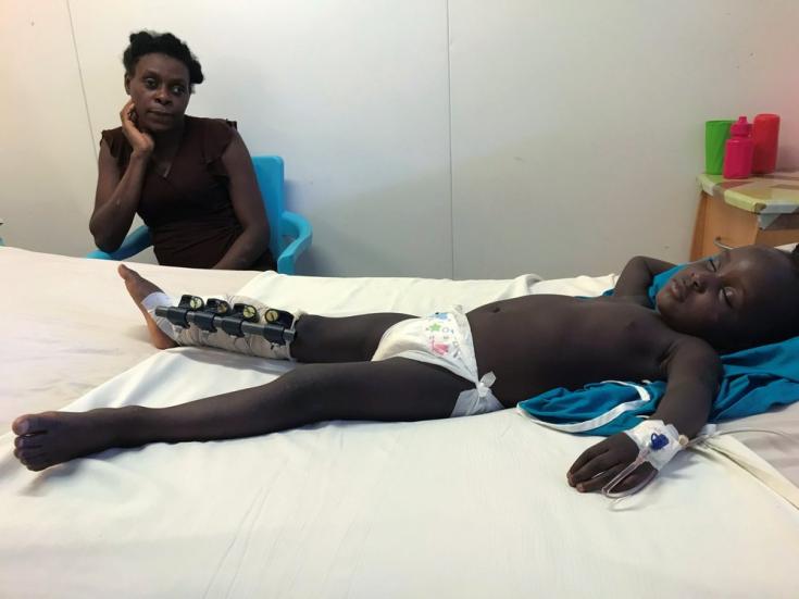 François Widnika, de 2 años y 7 meses, duerme en una cama de nuestro hospital Tabarre en Puerto Príncipe junto a su madre, Deus Widline, de 29 años. En el terremoto del 14 de agosto, una pared cayó sobre su pierna