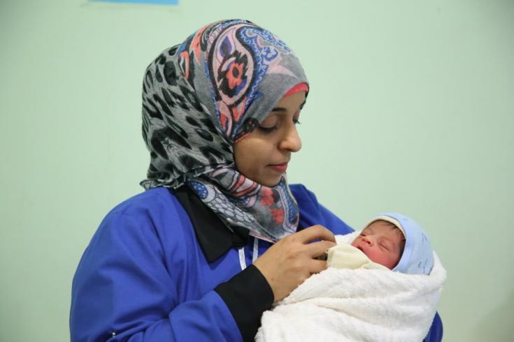 Amal, una partera de nuestros equipos, sostiene a un bebé en nuestro hospital materno infantil en la ciudad de Taiz, Yemen. Febrero de 2020 