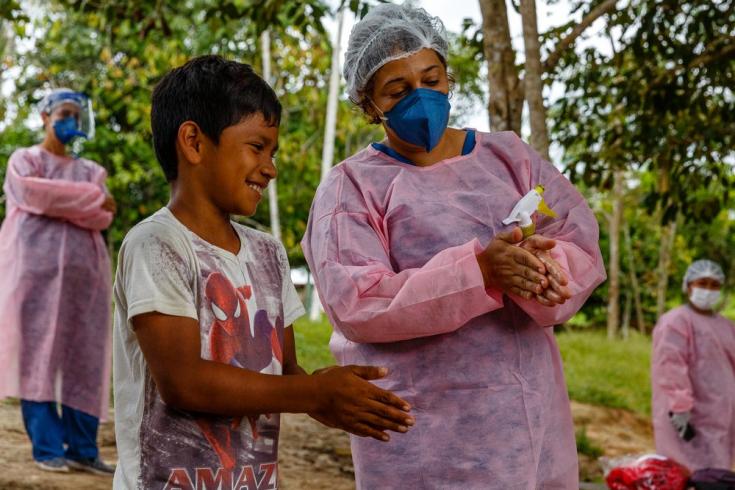 Una enfermera de MSF le enseña a un niño la forma correcta de lavarse las manos en una comunidad de Brasil.