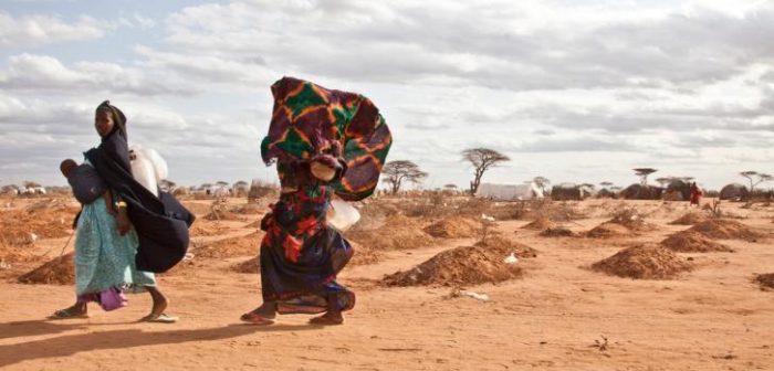 Refugiadas somalíes pasan a través de tumbas en el campo de refugiados de Dadaab ©Brendan Bannon