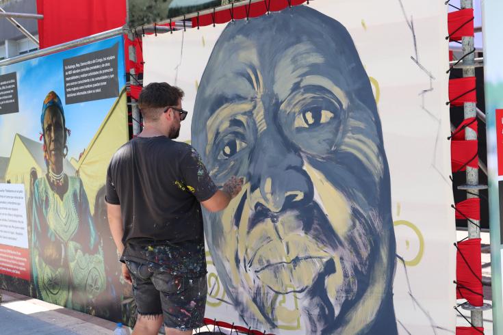 Alan Myers se inspiró en una foto de una trabajadora de Médicos Sin Fronteras para pintar un mural en uno de los paneles de la muestra.