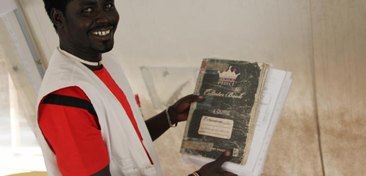 Jeremiah con el cuaderno que mantuvo a salvo durante 4 meses y que ayudó a retomar el tratamiento vital de decenas de pacientes. ©MSF