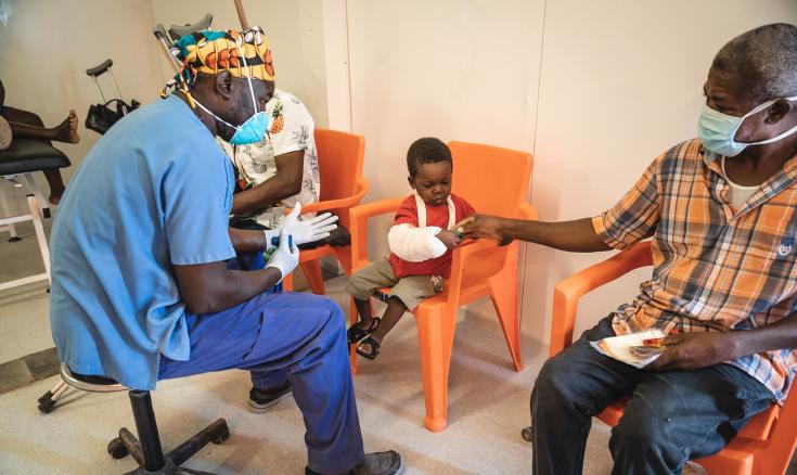  Niño juega con un fisioterapeuta para rehabilitar su brazo herido en el hospital de MSF en Puerto Príncipe.