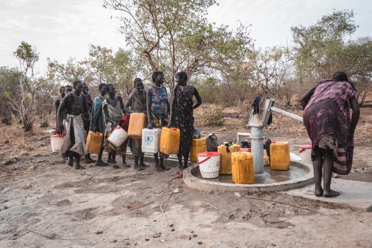 Las mujeres en Akelo, Labarab, esperan su turno para extraer agua del pozo manual.