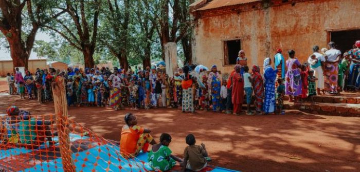 Mujeres, niñas y niños aguardan en el lanzamiento de nuestro campaña de inmunización en Ippy, el 4 de mayo de 2022. Esta campaña provee protección básica ante enfermedades como sarampión, polio, fiebre amarilla, meningitis y tuberculosis a aproximadamente 20.000 niñas y niños menores de 10 años, así como a 9.000 mujeres embarazadas.Khatab Muhy.