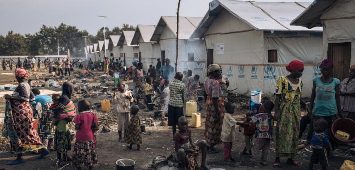 Un grupo de personas desplazadas prepara comida en frente de los refugios comunales del campo informal para personas desplazadas internamente de Rutshuru, en Kivu del Norte, al este de República Democrática del Congo.Alexis Huguet.