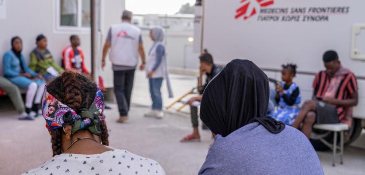 Nuestros y nuestras pacientes  pacientes en la sala de espera fuera de la clínica móvil en el Centro de Control de Acceso Cerrado de Zervou, Samos. 
Allí prestamos servicios de atención primaria, incluida salud sexual y reproductiva. También contamos con un equipo de promoción de la salud que visita el campo para debatir y aplicar prácticas de higiene y asegurarse de que la población conoce el apoyo que nuestra organización puede prestar a los pacientes.MSF/Evgenia Chorou.