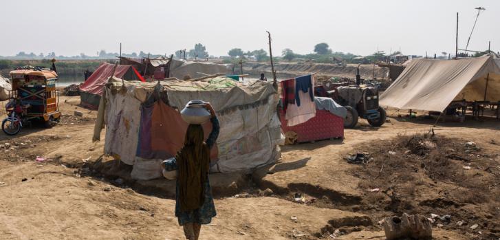 Imagen de archivo del 28 de octubre de 2022: una mujer lleva agua hacia su tienda en el campo para personas afectadas por las inundaciones en Sindh, Pakistán.Asim Hafeez.