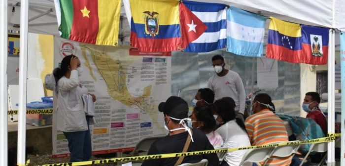 Una promotora de nuestras promotoras de salud explica el mapa de la ruta migratoria mientras las personas esperan recibir atención médica.MSF/Laura Aceituno.