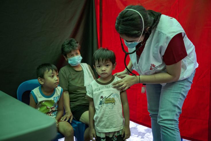 Abuela junto a sus nietos en un punto de detección activa de tuberculosis en Filipinas.