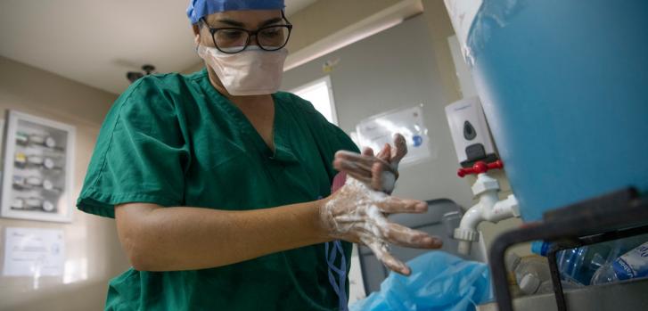 Una trabajadora de Médicos Sin Fronteras se lava las manos cumpliendo un estricto protocolo de bioseguridad, antes de salir del circuito de la unidad de COVID-19 que MSF opera en conjunto con el Hospital Pérez de León II en Caracas, Venezuela.Carlos Becerra/MSF