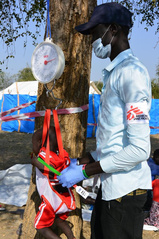 Un enfermero de MSF pesa a un bebé antes de una consulta médica en la clínica móvil de MSF ubicada en Riang, estado de Jonglei.