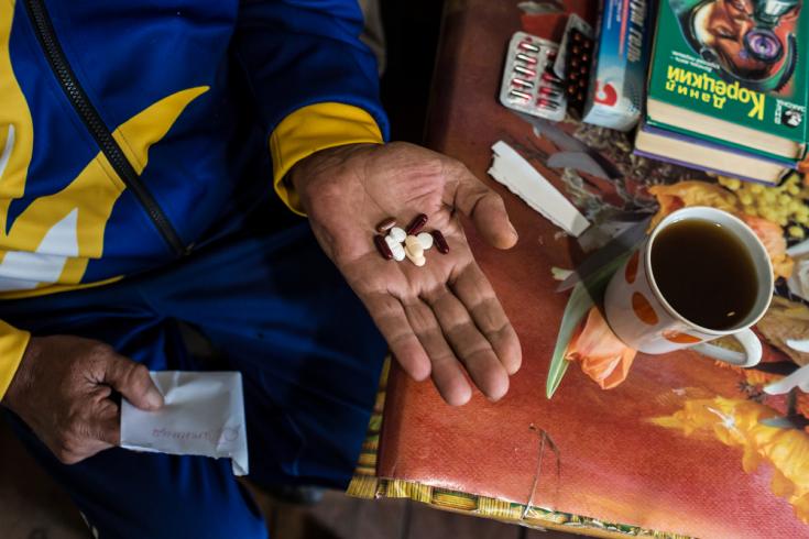 Paciente de 56 años toma sus pastillas de DR-TB en su casa.