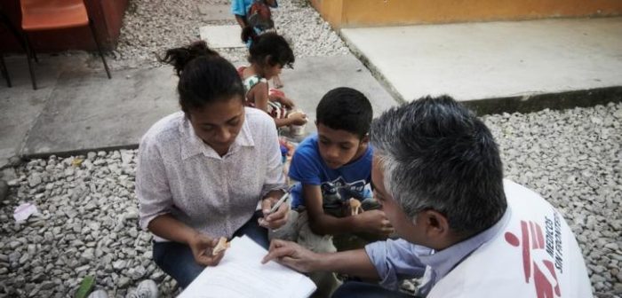 Un trabajador social de MSF proporciona orientación social y protección a una mujer migrante que viaja con sus hijos. ©MSF
