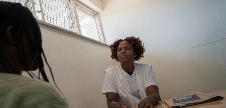 Olivia Mangwiro, psicóloga clínica, habla con una paciente en el ala de salud mental de la prisión de Chirubi. ©Rachel Corner/De Beeldunie