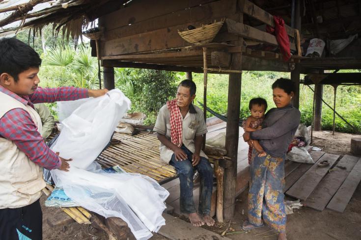 Un enfermero de MSF reemplaza las mosquiteras de la familia de a Saom Koem, quien recibió tratamiento para la malaria dos años atrás en Camboya (2016).