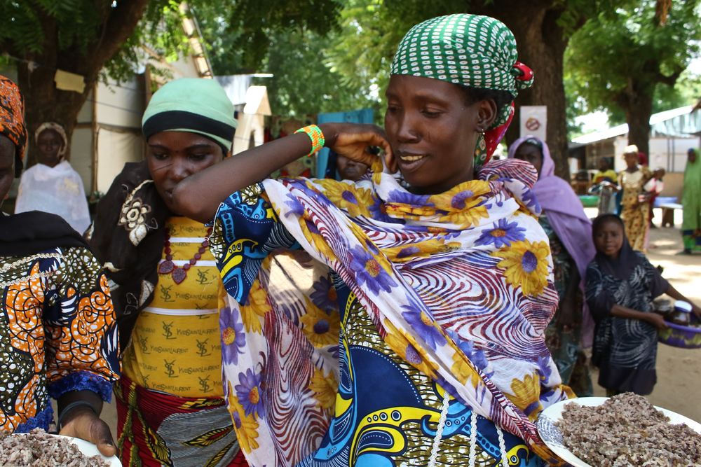 Absatou junto a otras madres y cuidadores regresan de la cocina con su almuerzo. La hija de Absatou, Fassouma, fue remitida al hospital porque sufría de malaria severa, gastroenteritis y una infección respiratoria. MSF proporciona comidas para las madres 