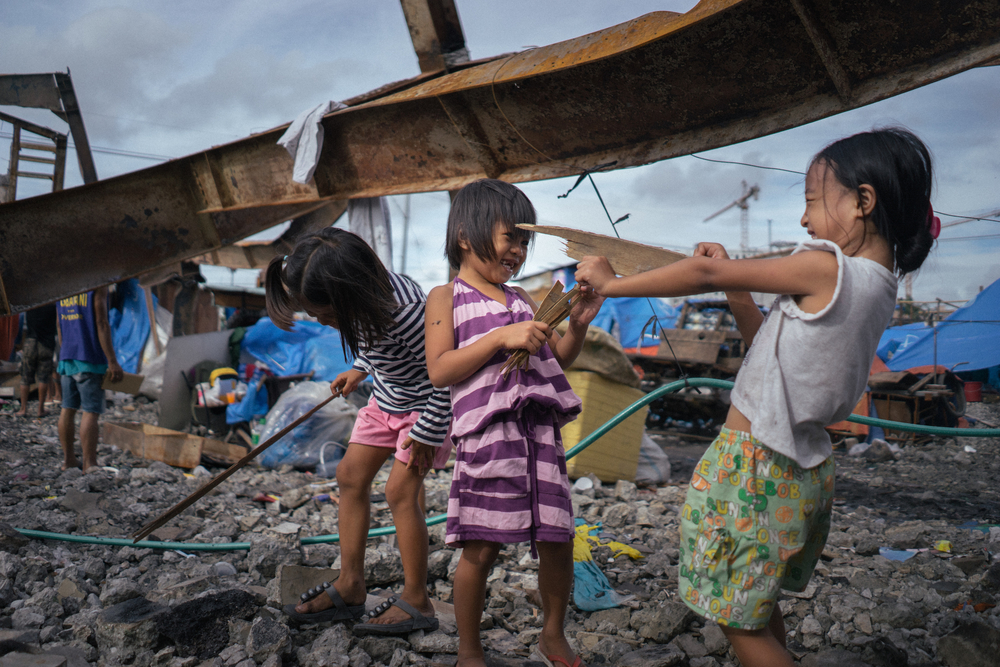 Se ve a los niños jugando entre los escombros después de que un incendio destruyera sus casas en Manila.