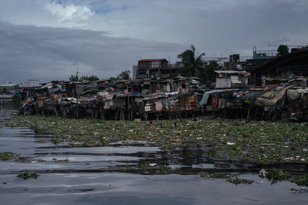 Las casas improvisadas de una comunidad de chabolas se ven junto al agua en Manila, Filipinas.