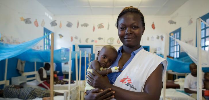 Patiente Ngangu, enfermera de Médicos Sin Fronteras (MSF) junto a Yapele, un paciente hospitalizado en la Unidad Terapéutica de Nutrición Intensiva del Hospital Bili, que cuenta con el apoyo de MSF en República Democrática del Congo.