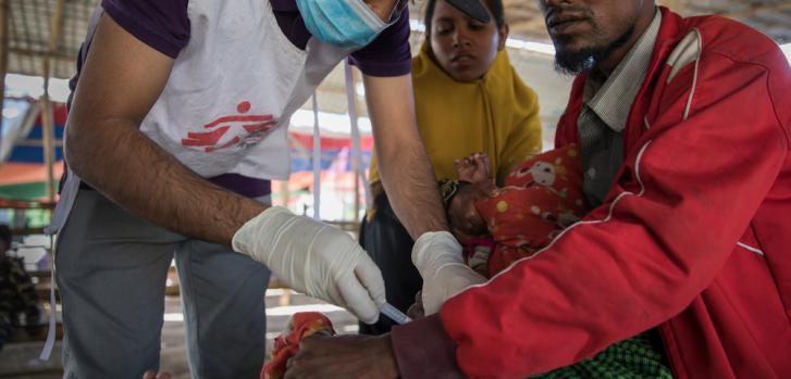 Boshir Ullah, un refugiado rohingya de 25 años recientemente llegado desde Myanmar con su esposa, su madre y sus tres hijos. En la foto, Ferungada, su hijo menor, recibe una vacuna en Sabrang.Anna Surinyach/MSF