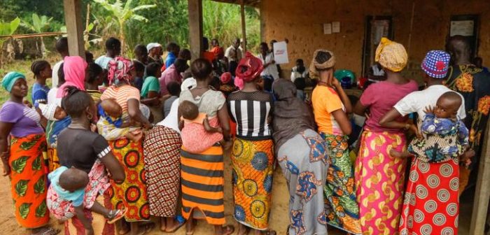 Habitantes del pueblo de Fomaya escuchando a Matu, un promotor de la salud de MSF, mientras ella explica cómo prevenir y detectar la malaria.Rocel Ann Junio/MSF