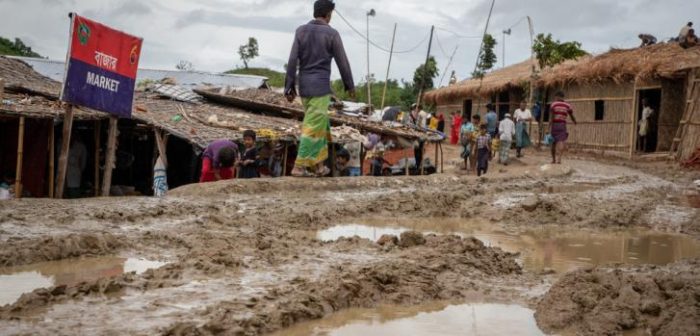 Los refugiados rohingya caminan por un camino embarrado después de las lluvias torrenciales en el campo de refugiados de Unchiprang. Decenas de miles de refugiados que viven en los campos en Cox's Bazar corren sufren inundaciones y deslizamientos de tierra durante la temporada del monzón.Daphne Tolis/MSF