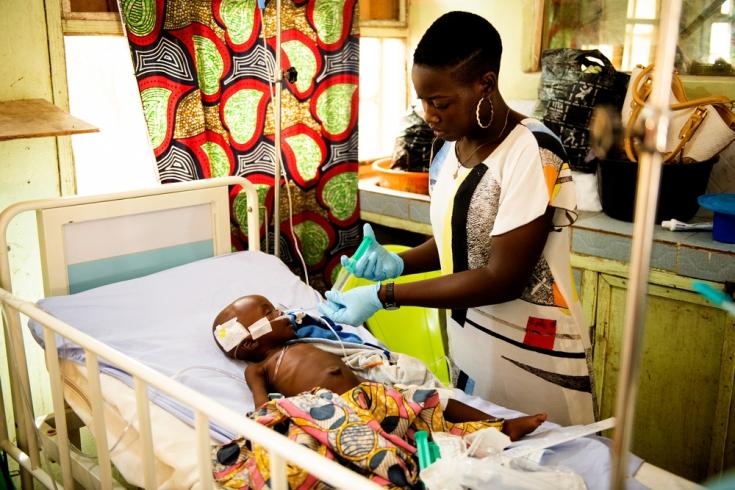 La enfermera Sarah Bature tratando a un niño que sufre las consecuencias de la desnutrición en la Unidad de Alta Dependencia de la sala de pediatría de MSF en el Hospital General de Anka.