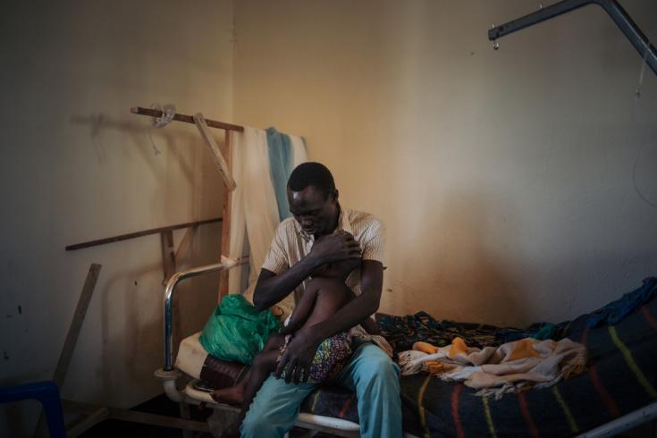 Joseph Drobho Giria sostiene a su hija de 2 años, Bhileru Drobho, en la unidad que dirigimos en el Hospital Biringi, en la provincia de Ituri. La pequeña tiene sarampión.