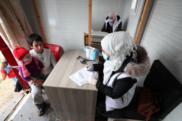 Una enfermera de MSF habla con un niño que trajo a uno de sus familiares para una consulta, en la clínica móvil de MSF, en un campamento de desplazados internos en el noroeste de Siria.