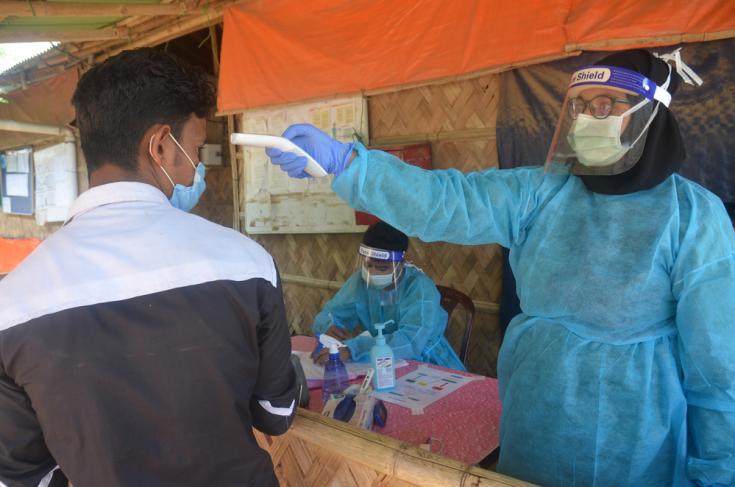 El personal de MSF examina a los pacientes para detectar síntomas respiratorios y fiebre en la entrada del hospital Goyalmara para madres e hijos en Cox’s Bazar, Bangladesh.