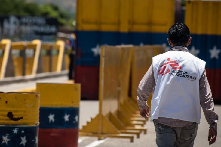 Un miembro del equipo de Médicos Sin Fronteras (MSF) cruza el Puente Simón Bolívar que conecta a Colombia con Venezuela. Cientos de venezolanos retornados cruzan el puente todos los días a pie para regresar a su país debido a la pandemia COVID-19.