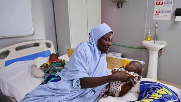 Madre junto a sus hijos en un centro de alimentación del noreste de Nigeria. 