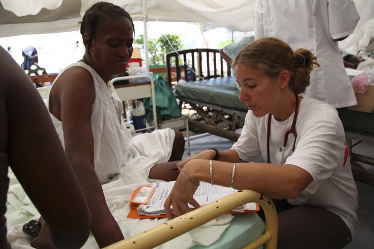 Carolina Nanclares atiende a una paciente en Haití. Los servicios para pacientes ambulatorios y para pacientes hospitalizados se realizaron debajo de carpas, ya que el hospital sufrió graves daños.