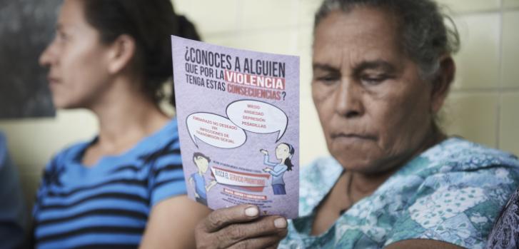 Una mujer lee un folleto de concientización acerca de la violencia. ©Christina Simons/MSF