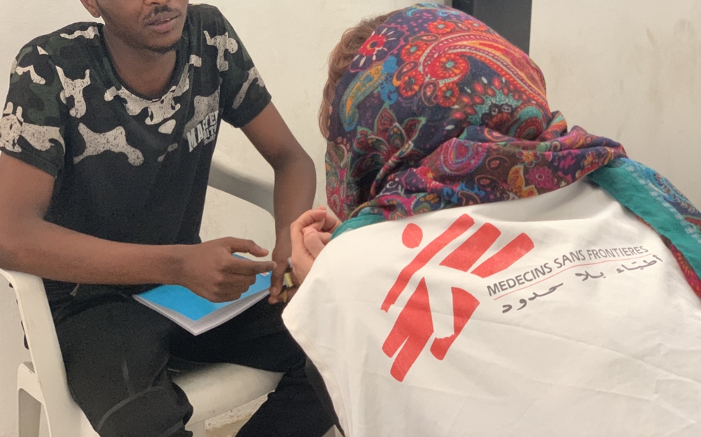 Imagen de archivo de 2019: Elham Gashout, médica de nuestra organización conversa con un joven recluido en el centro de detención de Abu Salim, en Trípoli © Sam Turner/MSF. 