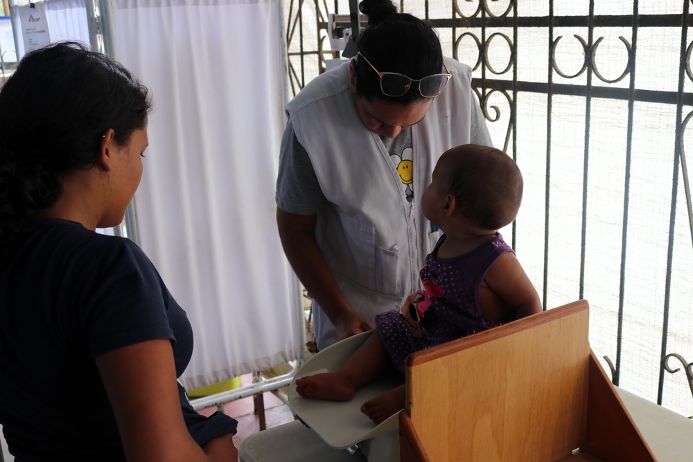 Personal de enfermería de MSF pesa y mide a una bebé migrante que llegó con su familia desde Venezuela.