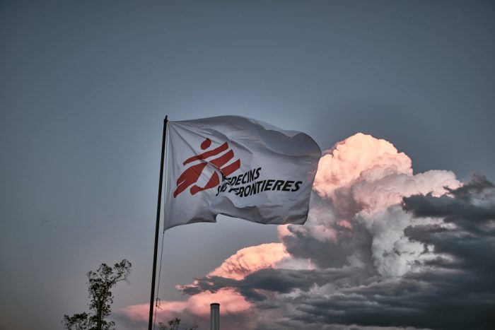 Bandera de la ONG Médicos Sin Fronteras ondenando en el atardecer