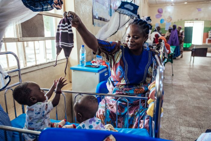 Una mujer juega con sus hijos, quienes se están recuperando de un caso de desnutrición en Nigeria.