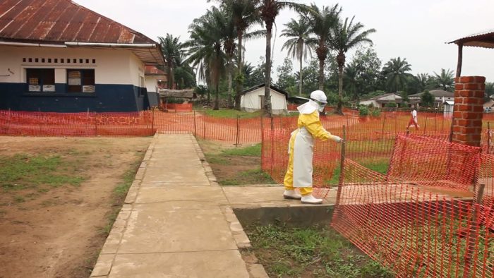 Un trabajador de la ONG Médicos Sin Fronteras con un traje apto para tratar el ébola ingresa en una clínica cercada.