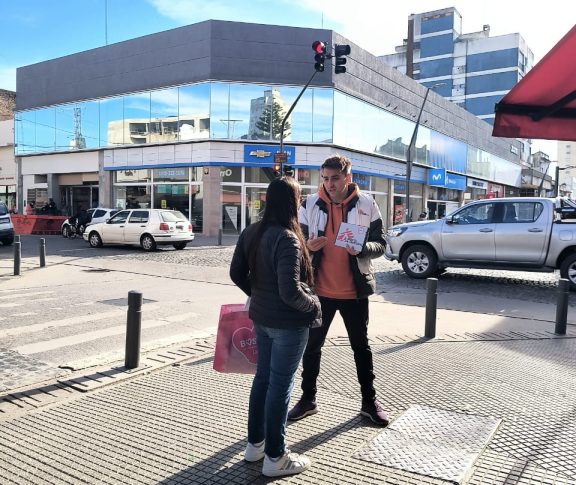 Trabajador de la ONG de Médicos Sin Fronteras hablando con una mujer en calle de Tandil.