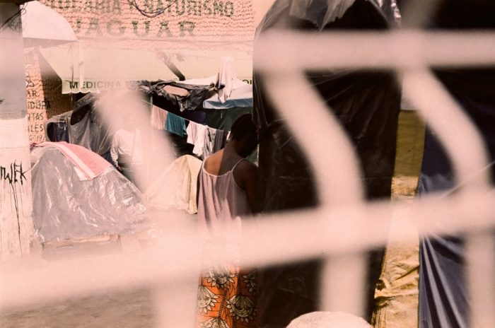 la migración extracontinental: una mujer cuelga la ropa en un campo de migrantes